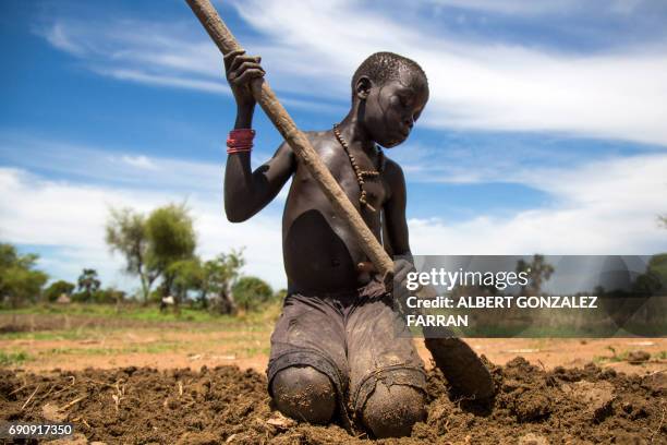 Nyibol Lual, 13 years old, helps her family to prepare the land for cultivation on May 31 in Panthau, Northern Bahr al Ghazal, South Sudan. The...