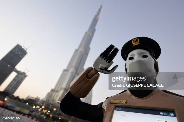 The world's first operational police robot stands at attention as they prepare a military cannon to fire to mark sunset and the end of the fasting...