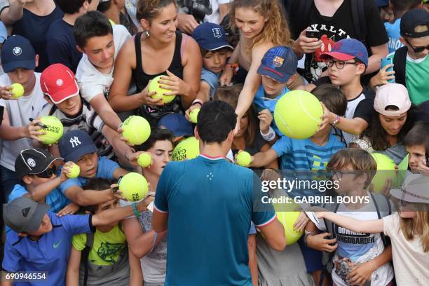 Canada's Milos Raonic signs autographs for children after winning his tennis match against Brazil's Rogerio Dutra Silva at the Roland Garros 2017...