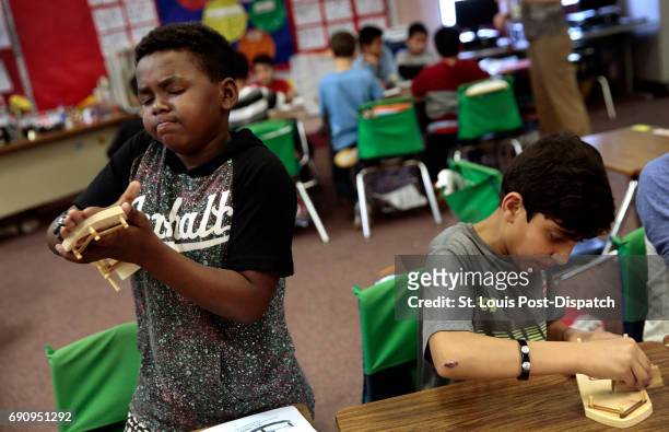 Fifth graders Sem Birke, left of Ethiopia and Hilal Safi of Afghanistan, sand their paddle wheelers as they make crafts on Thursday, April 20, 2017...