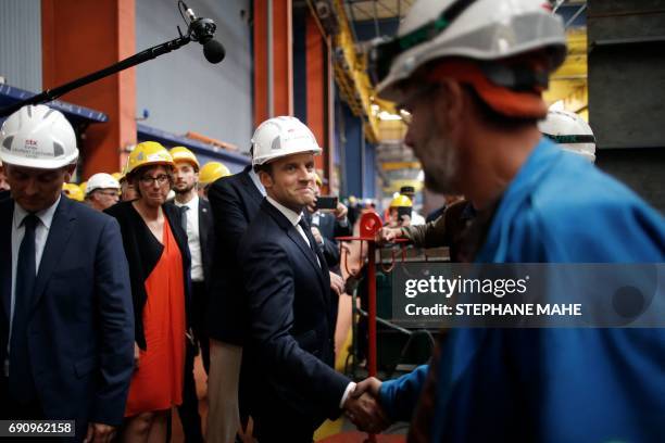 French President Emmanuel Macron shakes hands with a worker during the delivery ceremony of the MSC Meraviglia cruise ship on May 31, 2017 at the STX...