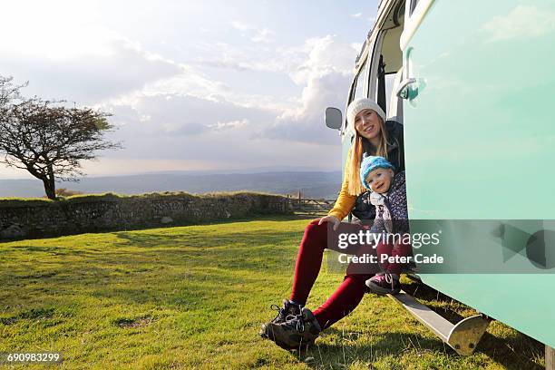 mother and daughter sat in camper on moors - mum sitting down with baby stockfoto's en -beelden
