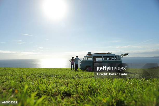 family with camper in field looking at sea - motor home foto e immagini stock