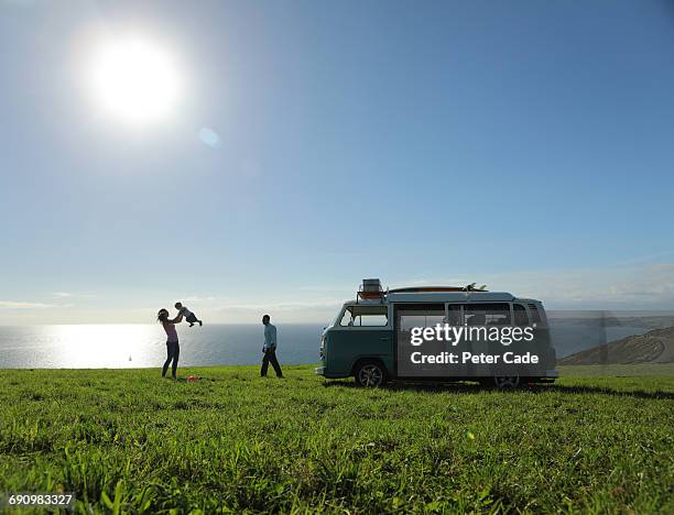 family with camper in field by sea - couple sea uk stock pictures, royalty-free photos & images