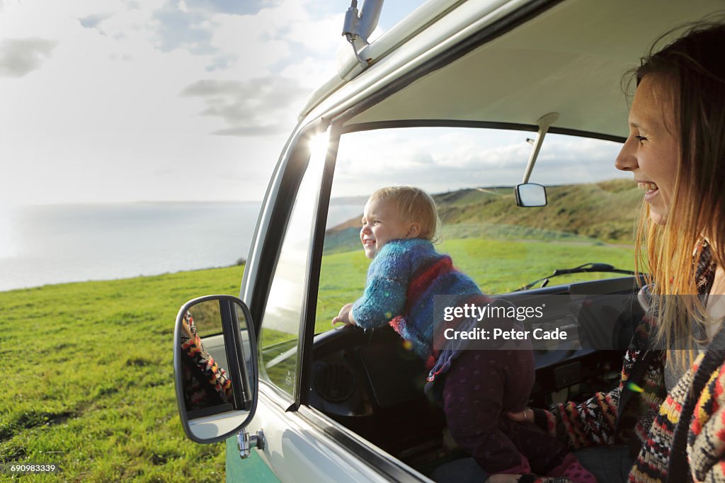 Toddler with mother looking out of camper