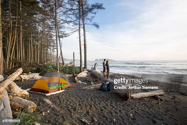 backpacking along a beach - yellow trousers stock-fotos und bilder