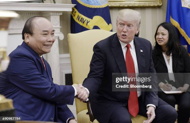 President Donald Trump, center, shakes hands with Nguyen Xuan Phuc, Vietnam's prime minister, left, during a meeting in the Oval Office of the White...