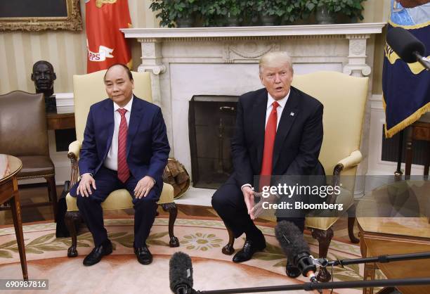 President Donald Trump, right, speaks to members of the media as Nguyen Xuan Phuc, Vietnam's prime minister, sits during a meeting in the Oval Office...