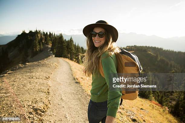 a woman on a day hike. - grüner hut stock-fotos und bilder