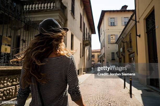 a woman walking the streets of italy - historic district stock-fotos und bilder