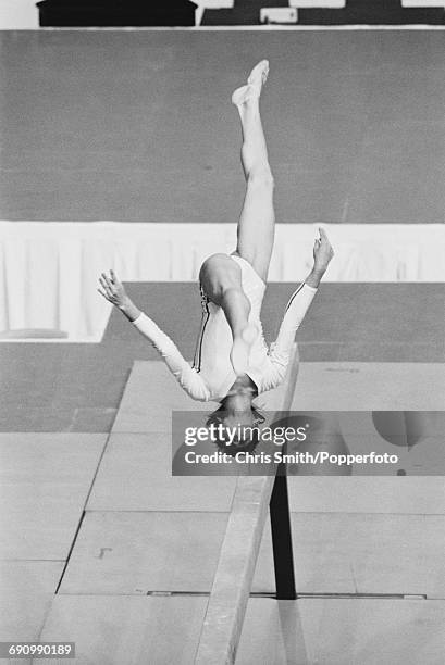 Romanian gymnast Nadia Comaneci, in action performing a somersault during competition on the balance beam, part of the women's artistic team...