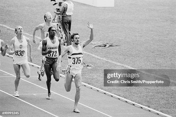 English middle distance runner Steve Ovett of the Great Britain team raises one arm as he finishes in first place in qualifying heat 3 of the Men's...
