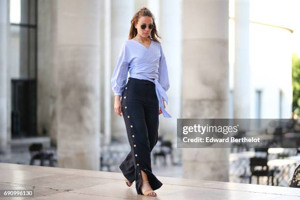 Amelie Lloyd wears Zara pants, a Zara striped top, and Zara shoes, at Palais de Tokyo, on May 30, 2017 in Paris, France.