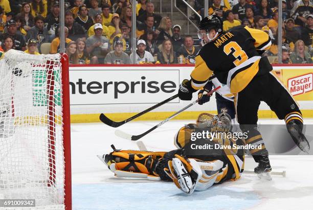 Olli Maatta of the Pittsburgh Penguins watches the puck over past goaltender Matt Murray on a shot by Pontus Aberg of the Nashville Predators during...