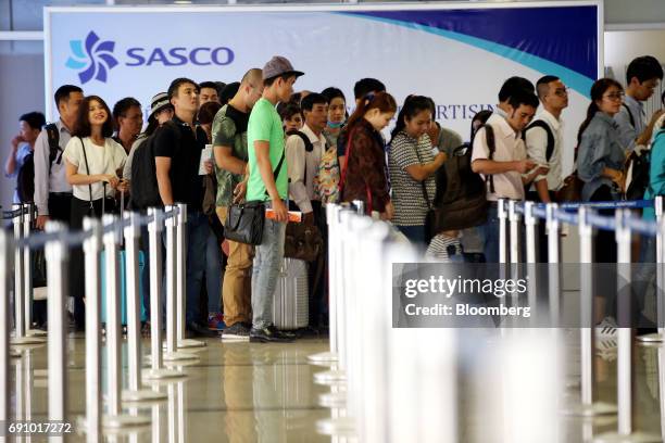 Passengers stand in line while waiting to check in for flights at Tan Son Nhat International Airport in Ho Chi Minh City, Vietnam, on Wednesday, Jan....