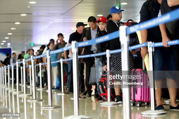 Passengers stand in line while waiting to check in for flights at Tan Son Nhat International Airport in Ho Chi Minh City, Vietnam, on Wednesday, Jan....