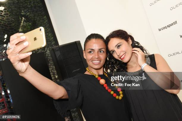 Presenters Laurence Roustandjee and Aida Touihri pose for a elfie during Le Coq Sportif x Guerlain photocall at the Le Coq Sportif Flagship on May...