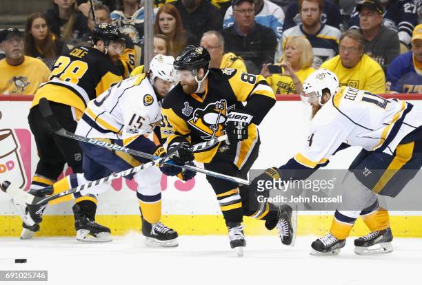 Phil Kessel of the Pittsburgh Penguins skates away with the puck between Craig Smith and Ryan Ellis of the Nashville Predators during the second...