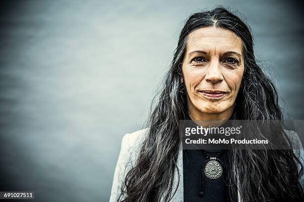 portrait of senior woman with long hair - grittywomantrend stock-fotos und bilder