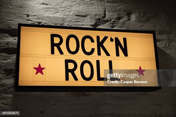 close-up of rockn roll signboard against gray wall - rock n roll foto e immagini stock