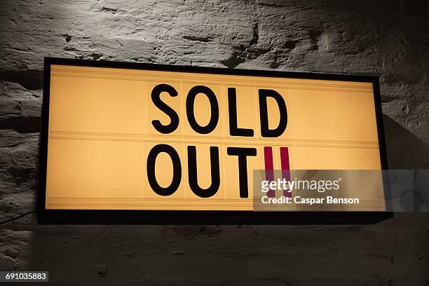 close-up of sold out signboard against gray wall - sold out stock-fotos und bilder
