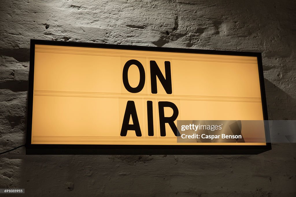 Close-up of On Air signboard against gray wall