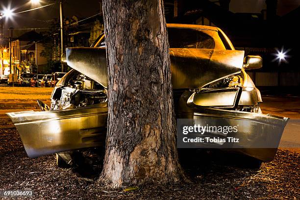 car crashed on tree trunk at night - verkeersongeluk stockfoto's en -beelden