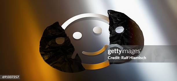 digitally generated image of smiley face behind torn sad face against colored background - anthropomorphic face stock illustrations