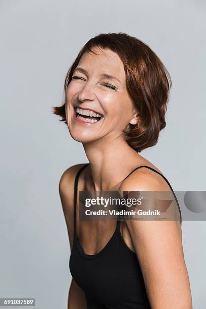 cheerful mature woman against gray background - hemden stockfoto's en -beelden