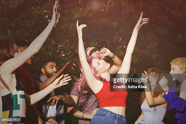 excited woman dancing with friends at yard during party - été fêtes photos et images de collection