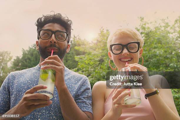 Low angle view of cheerful couple drinking lemonade at yard