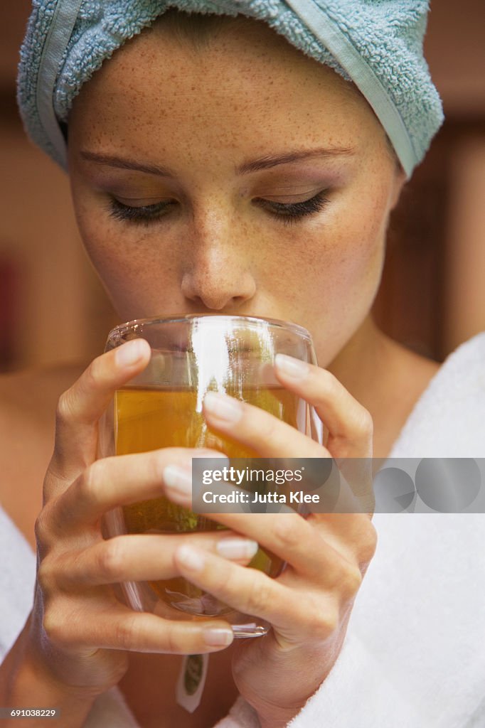 Close-up of woman drinking herbal tea at home