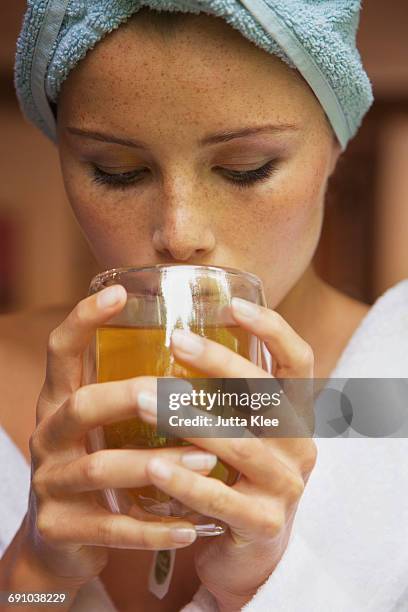 close-up of woman drinking herbal tea at home - tisana foto e immagini stock