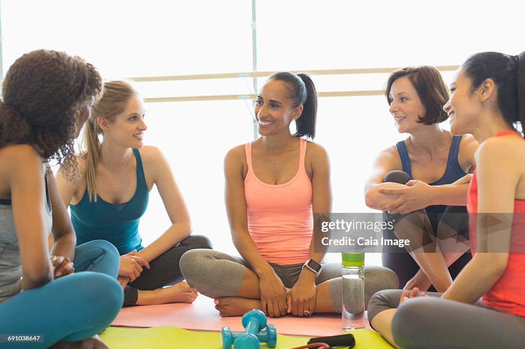 Smiling women talking in exercise class gym studio