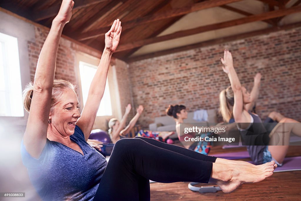 Mature woman doing core exercise in exercise class gym studio