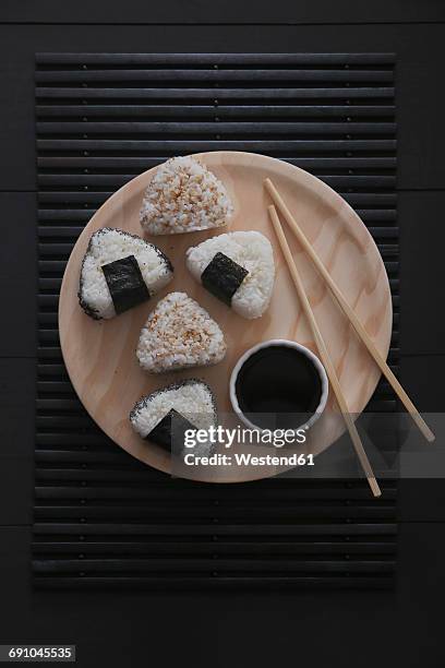onigiris, bowl with soy sauce and chopsticks on wooden plate - rice ball stock pictures, royalty-free photos & images