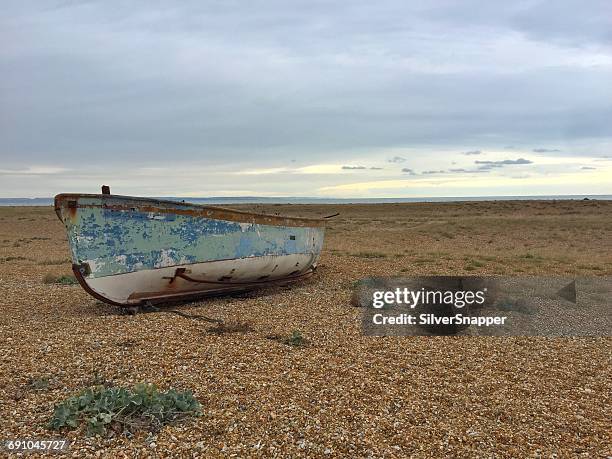 wooden rowing boat on beach, dungeness, kent, england, uk - abandoned boat stock pictures, royalty-free photos & images