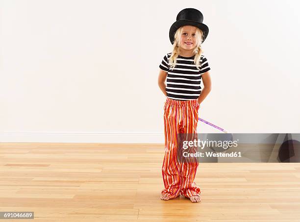 portrait of smiling girl with top hat and magic wand - zirkus kinder stock-fotos und bilder