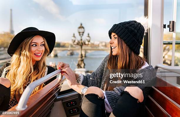 France, Paris, two smiling women on a tour bus