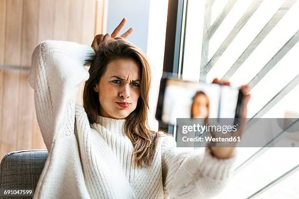 playful young woman taking a selfie with cell phone - television aerial stock pictures, royalty-free photos & images