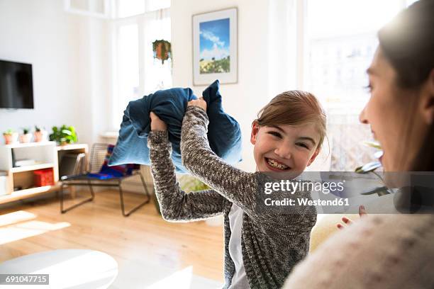 happy mother with daughter at home having a pillow fight - luta de almofada imagens e fotografias de stock