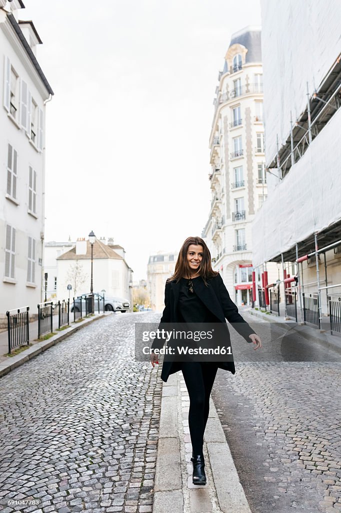 France, Paris, young woman walking on the streets of Montmartre