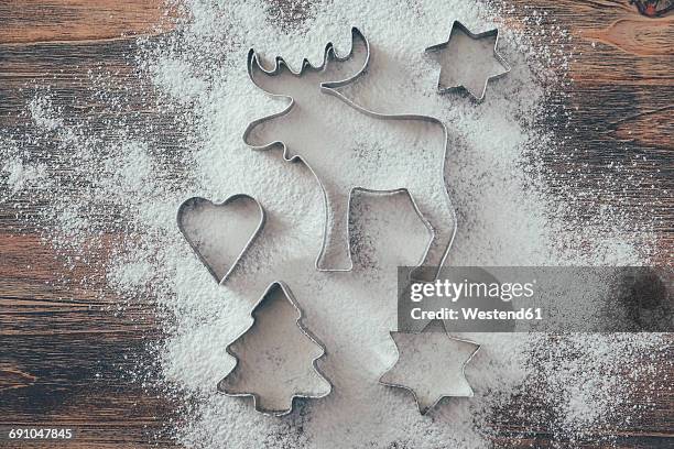 five cookie cutters sprinkled with flour on wood - pastry cutter fotografías e imágenes de stock