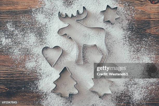 five cookie cutters sprinkled with flour on wood - formine foto e immagini stock