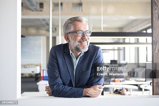 smiling businessman in office - looking away stockfoto's en -beelden