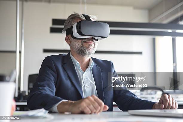 businessman in office wearing virtual reality glasses - virtualitytrend stock-fotos und bilder