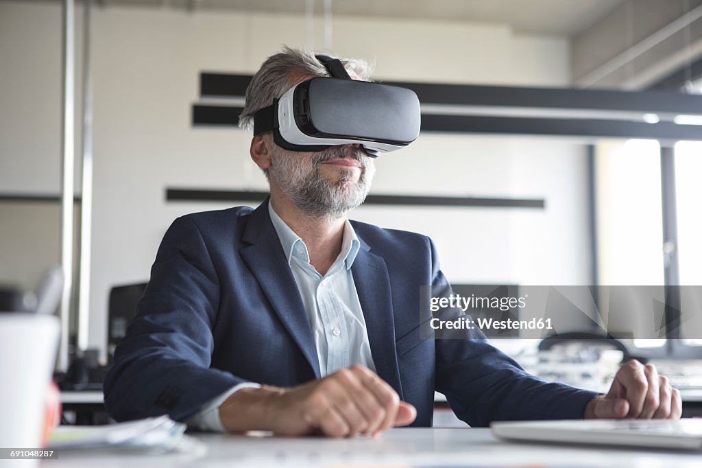 Businessman in office wearing virtual reality glasses