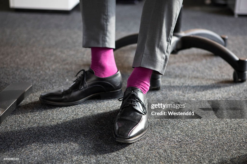 Close-up of businessman in office wearing pink socks