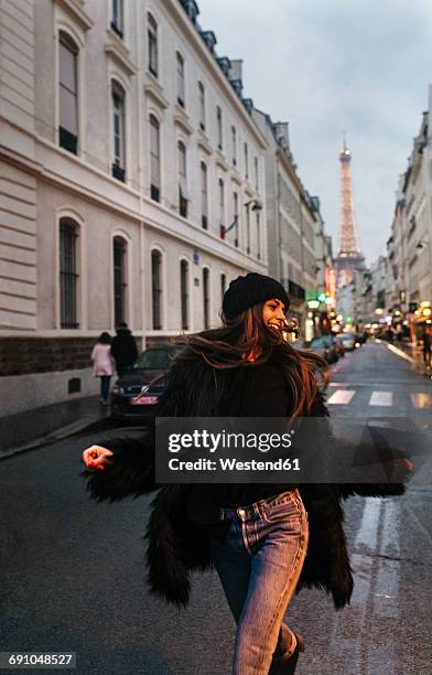 france, paris, young woman on the street with the eiffel tower in the background - paris street woman stock pictures, royalty-free photos & images