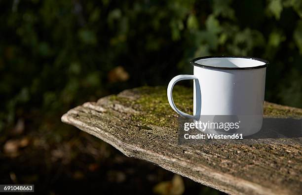 enamel mug on wooden bench - enamel stockfoto's en -beelden